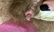 Ekstrem nærbilde av en stor klitoris fitte som blir gnidd og spruttet